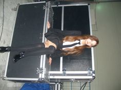 a woman standing in front of a metal case