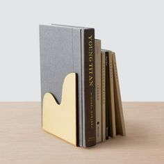 a stack of books sitting on top of a wooden table next to a book holder