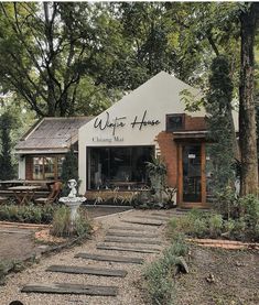 a building with stairs leading up to it in the middle of a garden area that is surrounded by trees