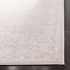 a large white rug on top of a wooden floor