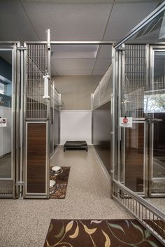 an empty hallway with mirrored doors leading to another room and a rug on the floor