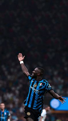 a soccer player in the air with his arms out and one hand up as he prepares to kick the ball