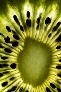 the inside of a kiwi fruit with black dots on it's center piece