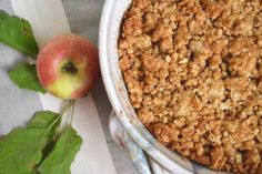 an apple pie sitting on top of a table next to a leafy green plant