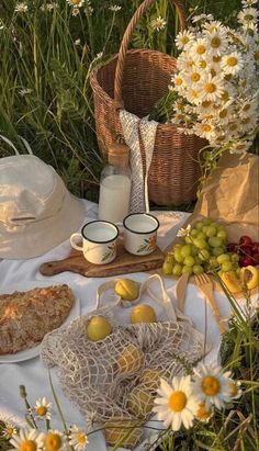 a picnic table with food and flowers in the background, including bread, milk, fruit, and yogurt