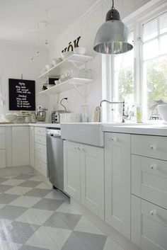 a kitchen with checkered flooring and white cabinets