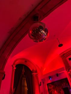 a red light shines in the middle of a room with chandeliers on it