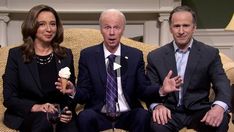 two men and a woman sitting on a couch with wine glasses in front of them