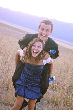 two people are posing for the camera in a field