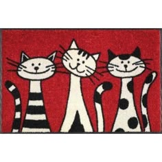 three cats standing next to each other on a door mat