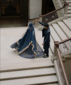 a man and woman standing on top of a set of stairs next to each other