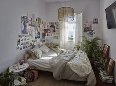 a bed room with a neatly made bed and lots of pictures on the wall