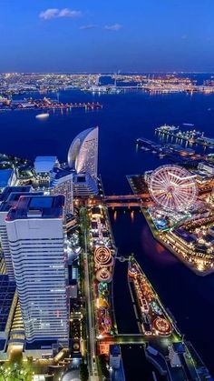 an aerial view of a city at night with the ferris wheel in the foreground