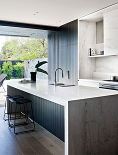 a modern kitchen with an island counter and bar stools