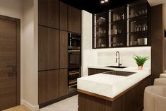 a modern kitchen with white counter tops and wooden cabinets