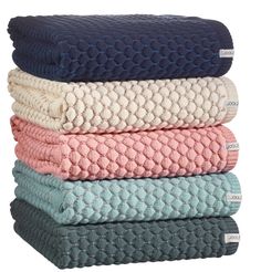 four towels stacked on top of each other in different colors and patterns, all folded together