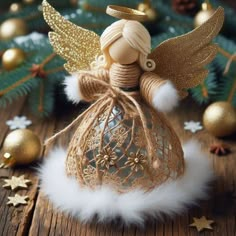 an angel figurine sitting on top of a wooden table next to christmas decorations