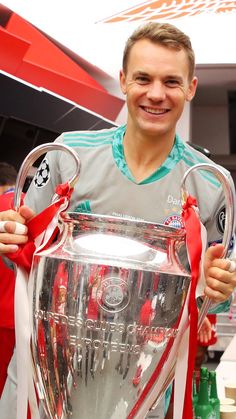 a man holding a soccer trophy in his hands