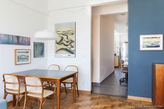 a dining room table with chairs and pictures on the wall