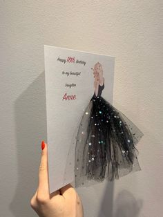 a hand holding up a card with an image of a woman's dress on it