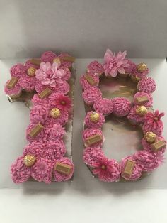 the letter d is made out of pink flowers and gold foiled chocolates on top