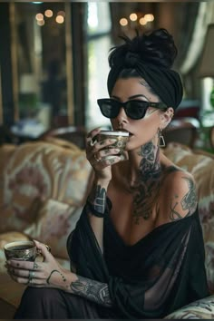 a woman with tattoos drinking from a cup