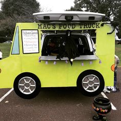 the food truck is parked in the parking lot with its door open and people standing around it