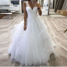 a woman is taking a selfie in her wedding dress while looking at her cell phone