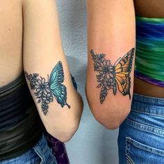 two women with tattoos on their arms and one has a butterfly tattoo on her arm