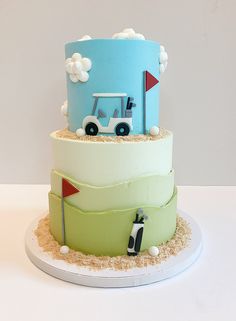 a three tiered cake with a golf cart on the top and sand around it