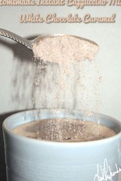 a spoon is pouring some sugar into a cup