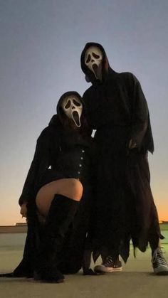 two people dressed up in halloween costumes posing for the camera with their faces painted white