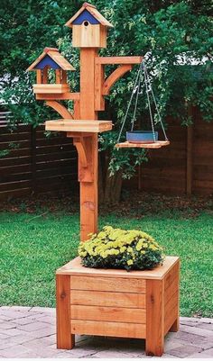 a wooden bird house with two birds on it's roof and a planter in the foreground