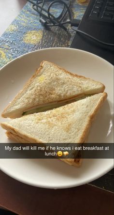 a white plate topped with a cut in half sandwich next to a computer keyboard and mouse