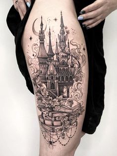 a woman's thigh with a castle tattoo on it