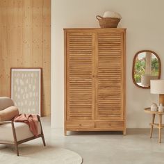 a living room with a chair, mirror and wooden cabinet in it's corner