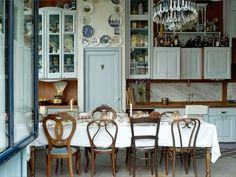 a dining room table with chairs and plates on the wall