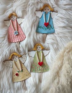 four little angel cupcake toppers on a furry surface