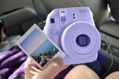 a person holding up a polaroid camera in their hand