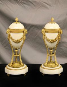 two white and gold vases sitting next to each other