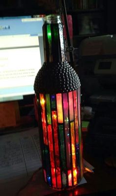 a multicolored lamp sitting on top of a desk next to a computer monitor