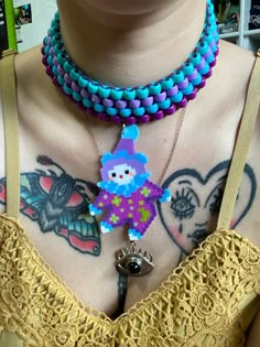 a close up of a person wearing a necklace with an evil clown charm on it