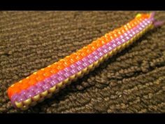 an orange, purple, and yellow beaded object laying on top of a brown carpet