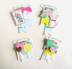 three pieces of paper are attached to clothes pins and hang on hooks with magnets