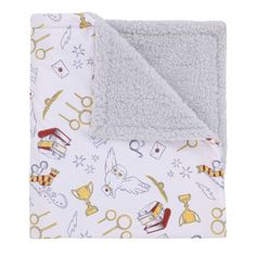 a baby blanket with scissors and other items on it, sitting next to a white background