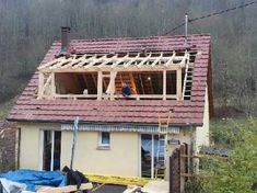 an image of a house being built with the roof ripped off and some people standing on it