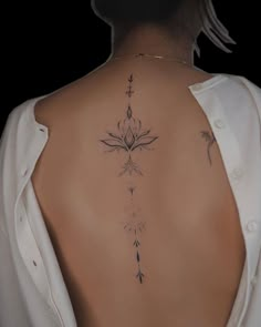 the back of a woman's neck with tattoos on it