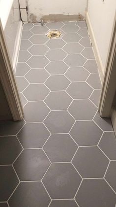 an open door leading to a bathroom with hexagonal tiles