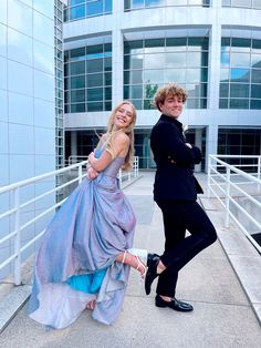 two people posing for a photo in front of a building