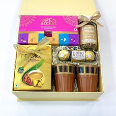 an open gift box filled with assorted chocolates and coffee items on a white surface